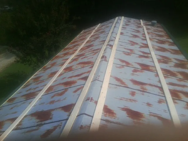 Rusted metal roof panels with new wood purlins before replacement — Storm Damage Roof Repair in Alton by Roofing Brothers