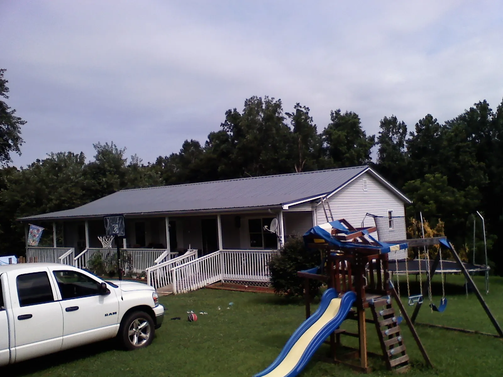 Dark metal roof on a country home with a full length front porch in Alton