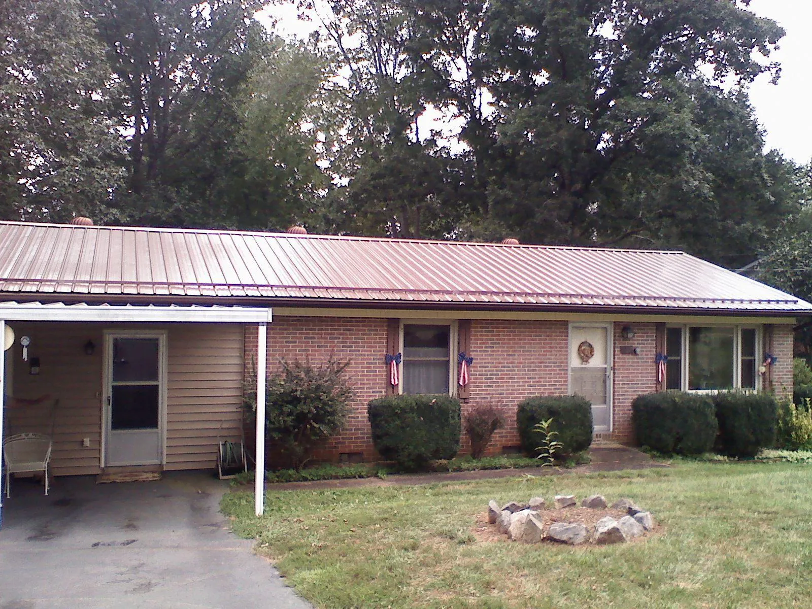 Bronze metal roof and carport on a brick ranch home — Roof Repair work by our crew in Alton
